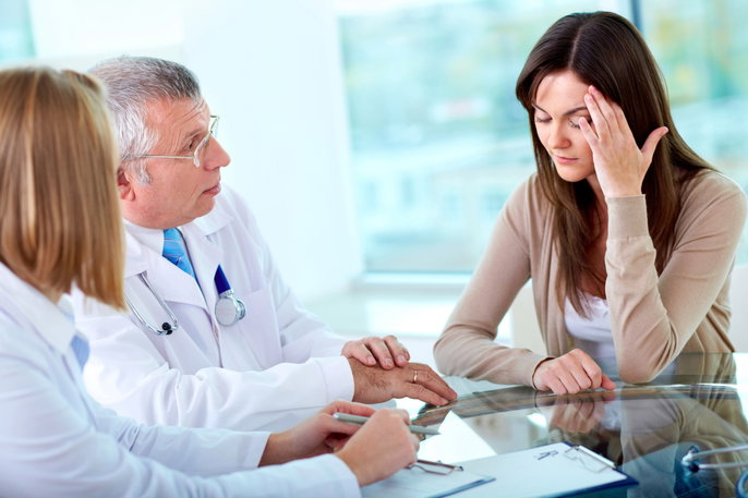 Mujer en consulta médica por dolor de cabeza