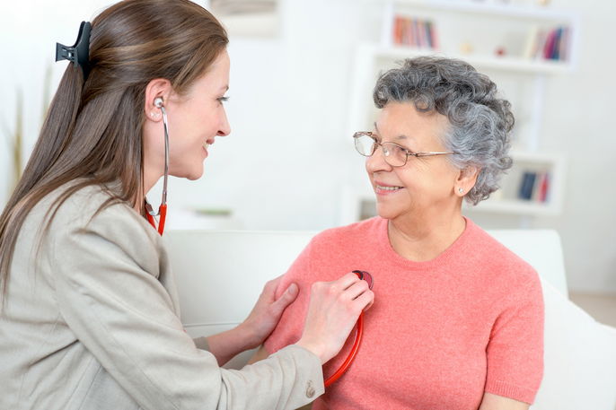 Médica cardiologista escutando o coração de paciente idosa