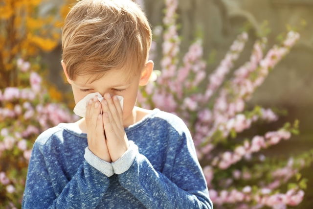 Criança espirrando devido a alergia respiratória ao pólen