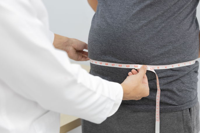 Doctor measuring patient's visceral fat through waist circumference