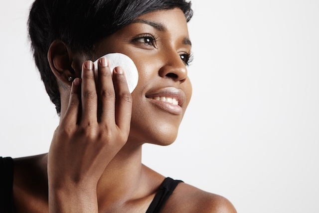 woman applying product to her face with a makeup sponge