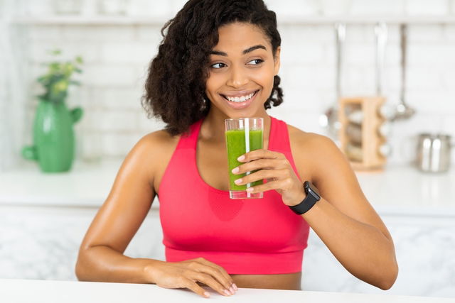 Mujer tomando jugo verde