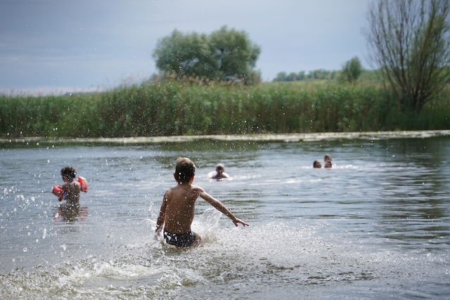 Crianças brincando nas águas de uma lagoa natural