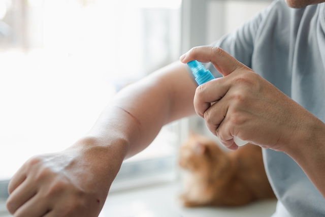 Hombre aplicando spray antiséptico a un corte en su piel