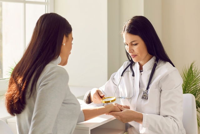 Médica dermatologista examinando a pele de paciente