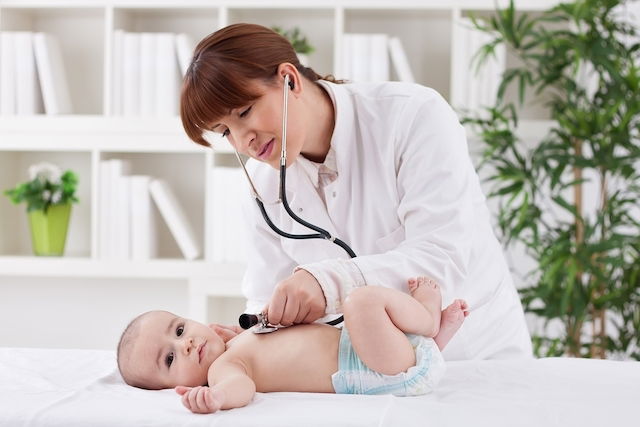 Médico auscultando el pecho de un bebé