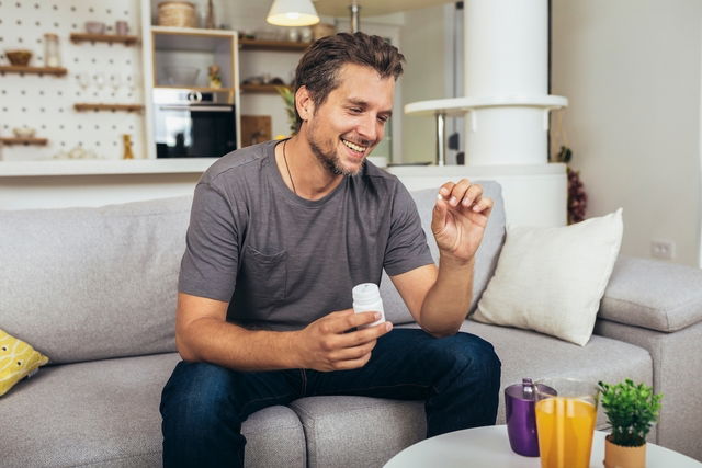 Hombre tomando comprimidos de ciprofibrato