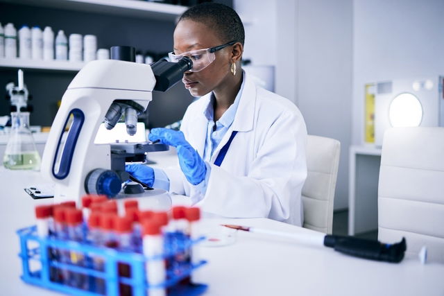 Mulher avaliando amostra de sangue em laboratório