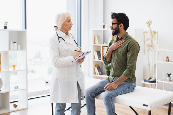 doctor speaking to patient with hand on his chest