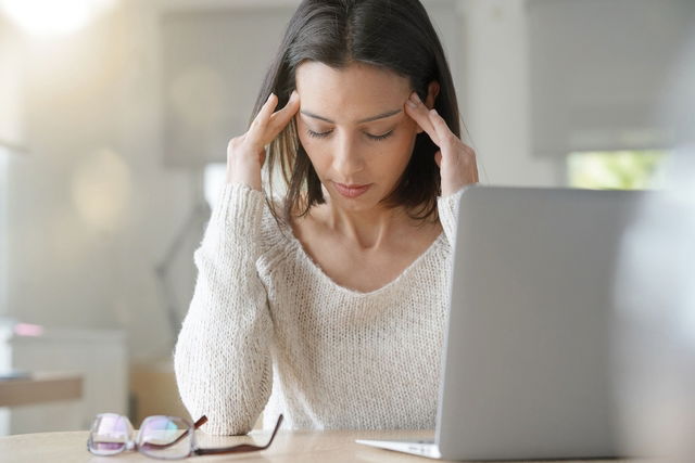 femme souffrant de mal de tête, se touchant la tête